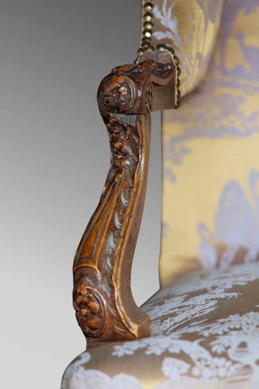 A 19th-century French Louis XV style wingback armchair with carved wood framing, cabriole legs, and gold pattern damask upholstery. View VIII