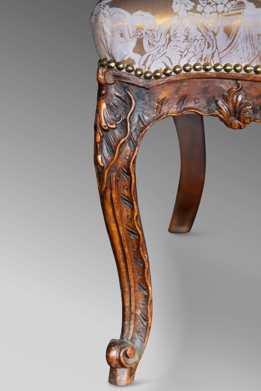 A 19th-century French Louis XV style wingback armchair with carved wood framing, cabriole legs, and gold pattern damask upholstery. View IX