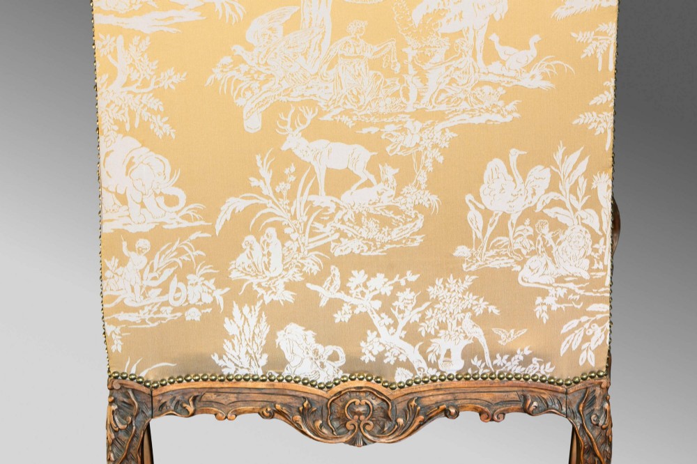 A 19th-century French Louis XV style wingback armchair with carved wood framing, cabriole legs, and gold pattern damask upholstery. View XI