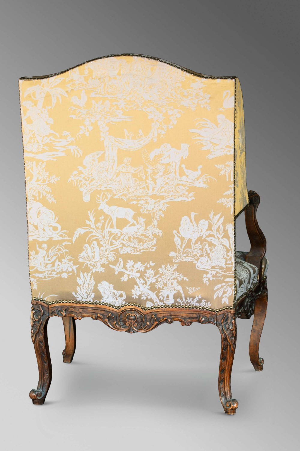 A 19th-century French Louis XV style wingback armchair with carved wood framing, cabriole legs, and gold pattern damask upholstery. View XII