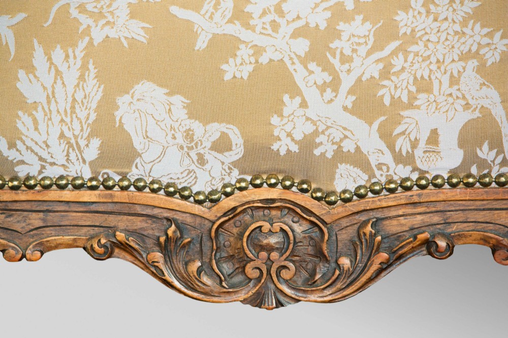 A 19th-century French Louis XV style wingback armchair with carved wood framing, cabriole legs, and gold pattern damask upholstery. View XIII