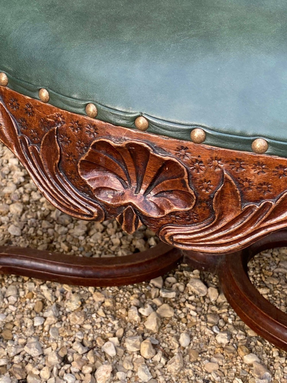 An eighteenth-century French walnut fauteuil armchair upholstered in dark green leather with brass studding, carved apron details, and curved legs. View IV