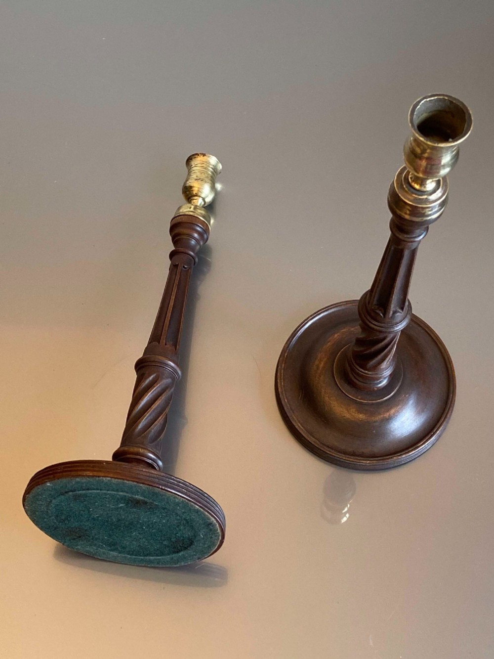 A pair of turned dark mahogany candlesticks featuring fluted and spiral columns topped with brass nozzles on circular bases. View III
