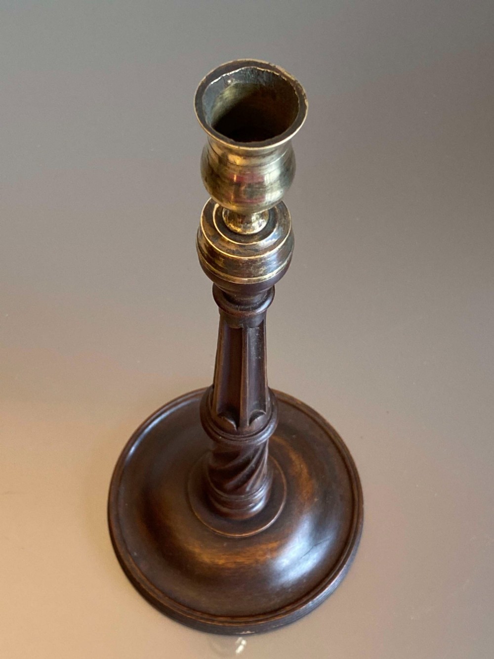 A pair of turned dark mahogany candlesticks featuring fluted and spiral columns topped with brass nozzles on circular bases. View IV