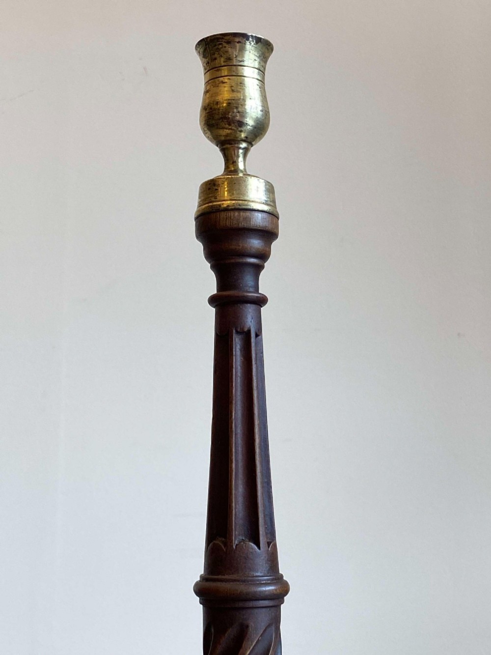 A pair of turned dark mahogany candlesticks featuring fluted and spiral columns topped with brass nozzles on circular bases. View VI