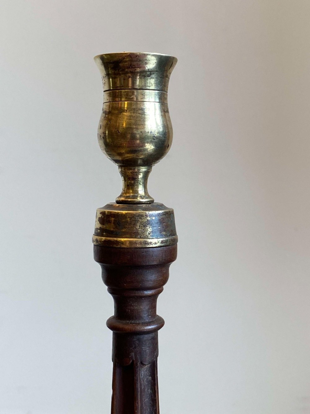 A pair of turned dark mahogany candlesticks featuring fluted and spiral columns topped with brass nozzles on circular bases. View VIII