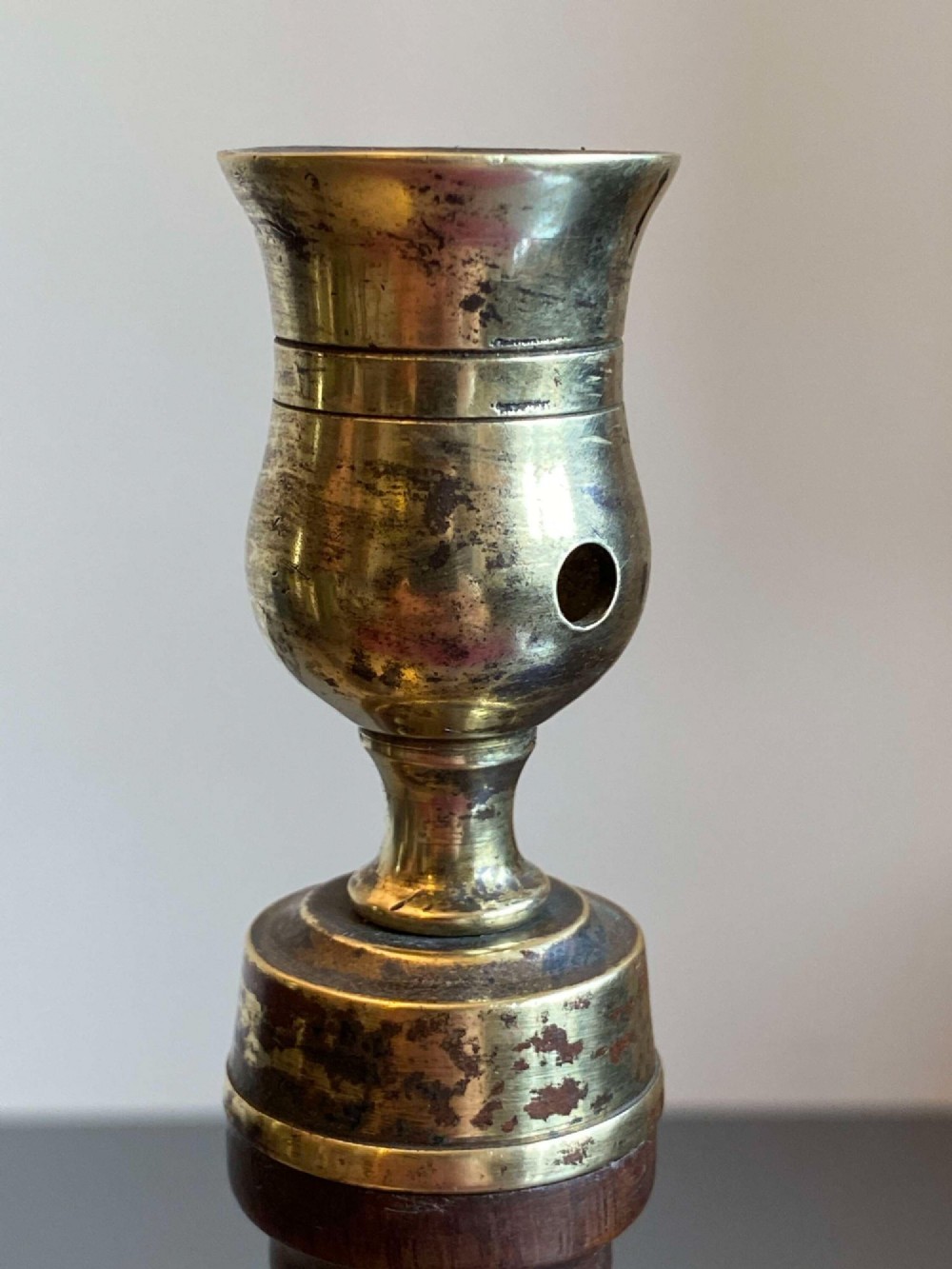 A pair of turned dark mahogany candlesticks featuring fluted and spiral columns topped with brass nozzles on circular bases. View IX