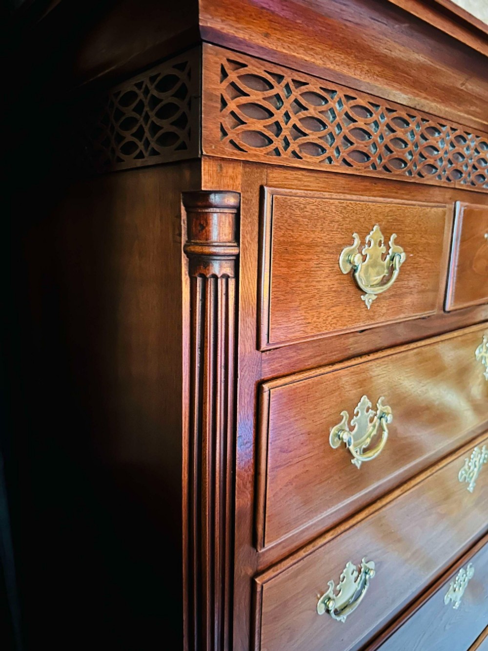 A tall 19th-century walnut chest of drawers featuring a carved fretwork frieze, brass backplate handles, and graduated drawer fronts. View III