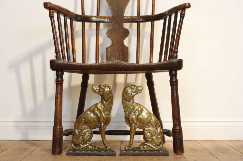 A pair of 19th-century cast brass doorstops crafted in the likeness of seated hunting dogs on rectangular bases.