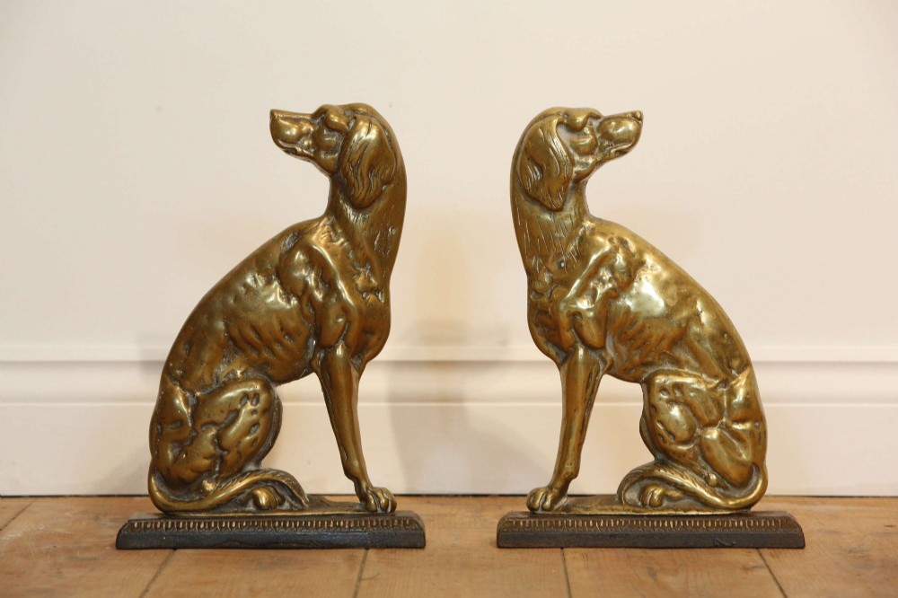 A pair of 19th-century cast brass doorstops crafted in the likeness of seated hunting dogs on rectangular bases. View V