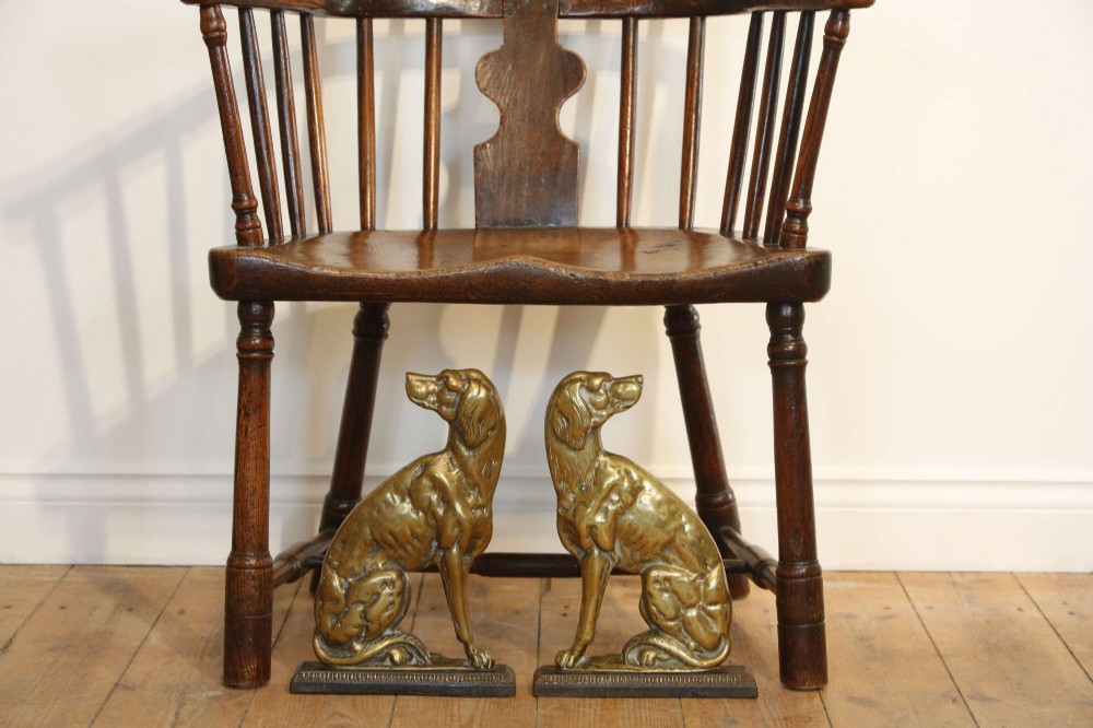 A pair of 19th-century cast brass doorstops crafted in the likeness of seated hunting dogs on rectangular bases. View VI