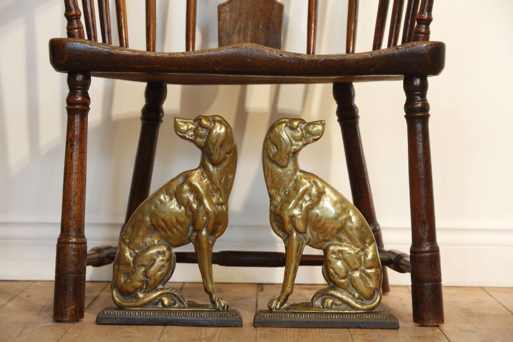 A pair of 19th-century cast brass doorstops crafted in the likeness of seated hunting dogs on rectangular bases. View VII