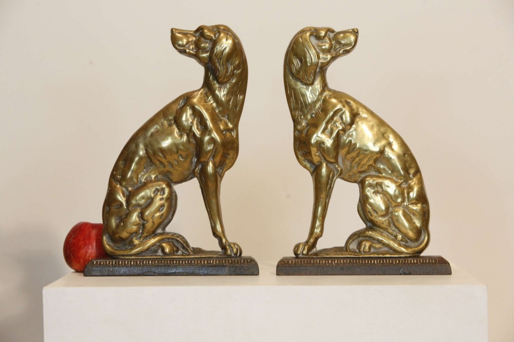 A pair of 19th-century cast brass doorstops crafted in the likeness of seated hunting dogs on rectangular bases. View IX