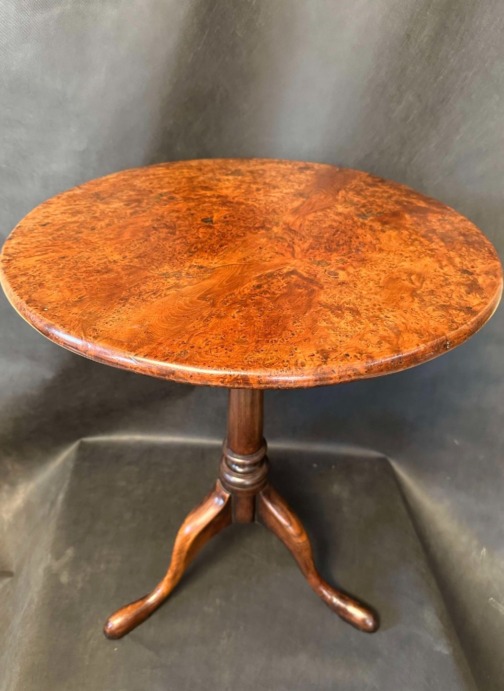 A Georgian circular occasional table crafted from burr yew wood featuring a turned central pedestal and a tripod base. View II