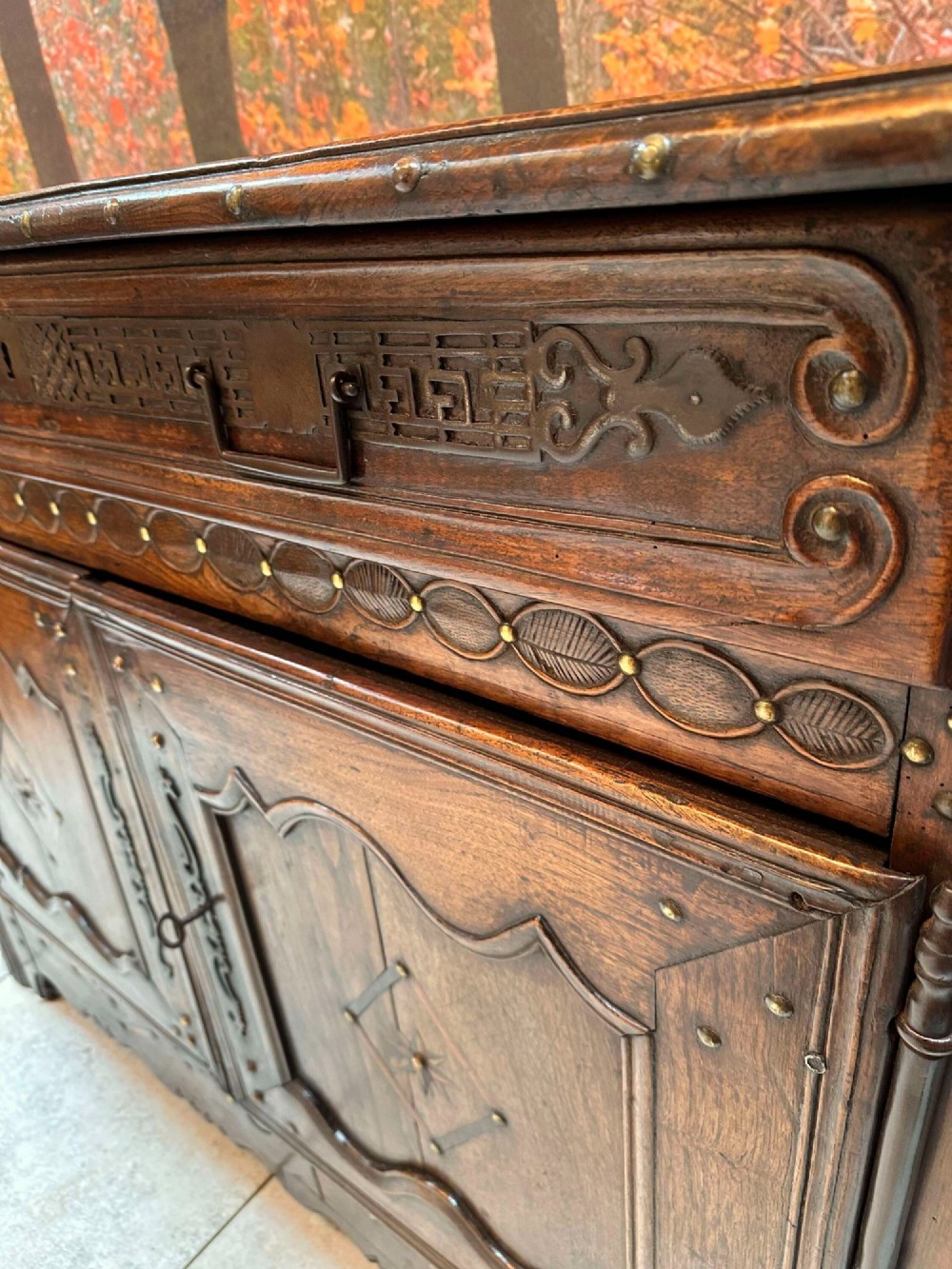 An antique French chestnut buffet featuring a carved top drawer band, two moulded door panels with carved star motifs, and iron hardware. View VIII