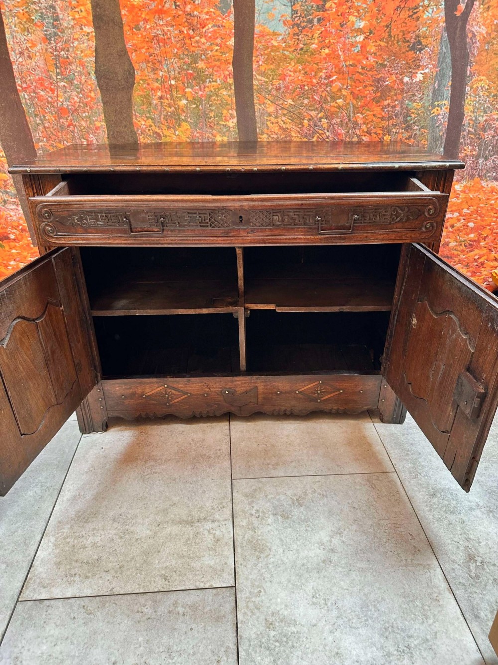 An antique French chestnut buffet featuring a carved top drawer band, two moulded door panels with carved star motifs, and iron hardware. View XI
