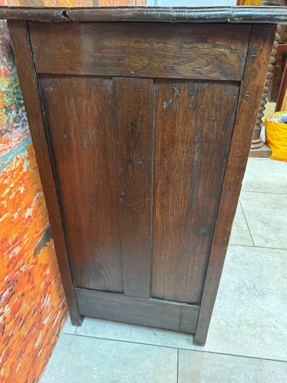 An antique French chestnut buffet featuring a carved top drawer band, two moulded door panels with carved star motifs, and iron hardware. View XIII