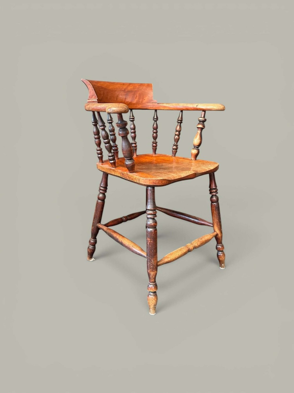 An antique alder wood Windsor captains chair featuring turned spindles, a contoured saddle seat, and high turned legs joined by stretchers. View III