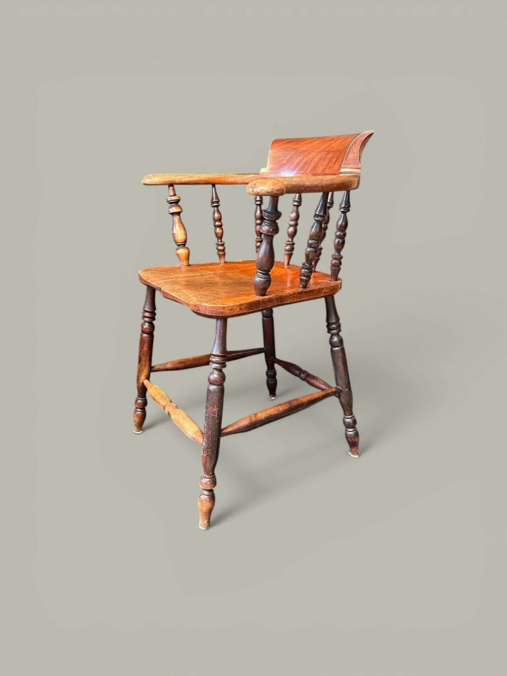 An antique alder wood Windsor captains chair featuring turned spindles, a contoured saddle seat, and high turned legs joined by stretchers. View IV