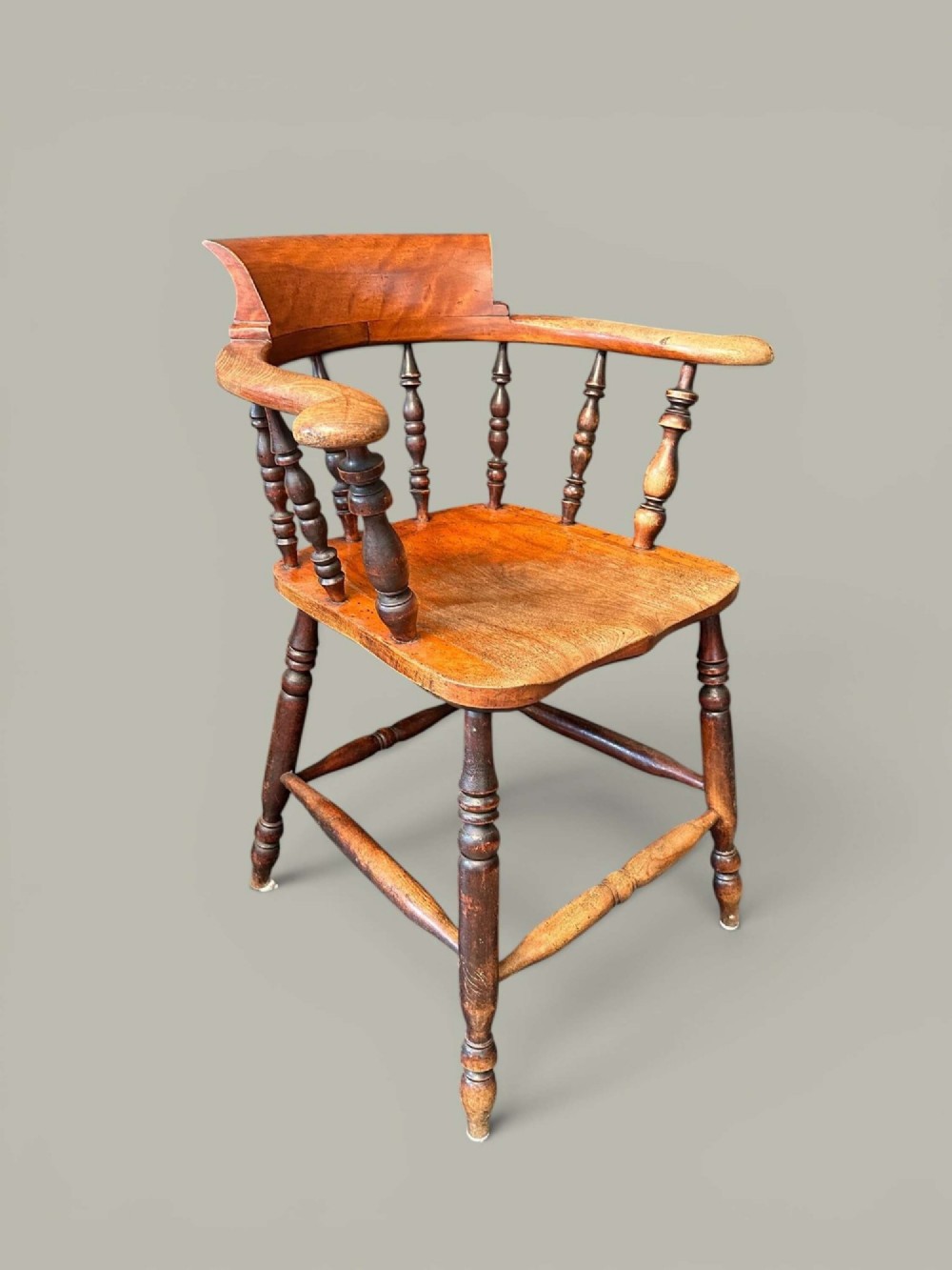 An antique alder wood Windsor captains chair featuring turned spindles, a contoured saddle seat, and high turned legs joined by stretchers. View V