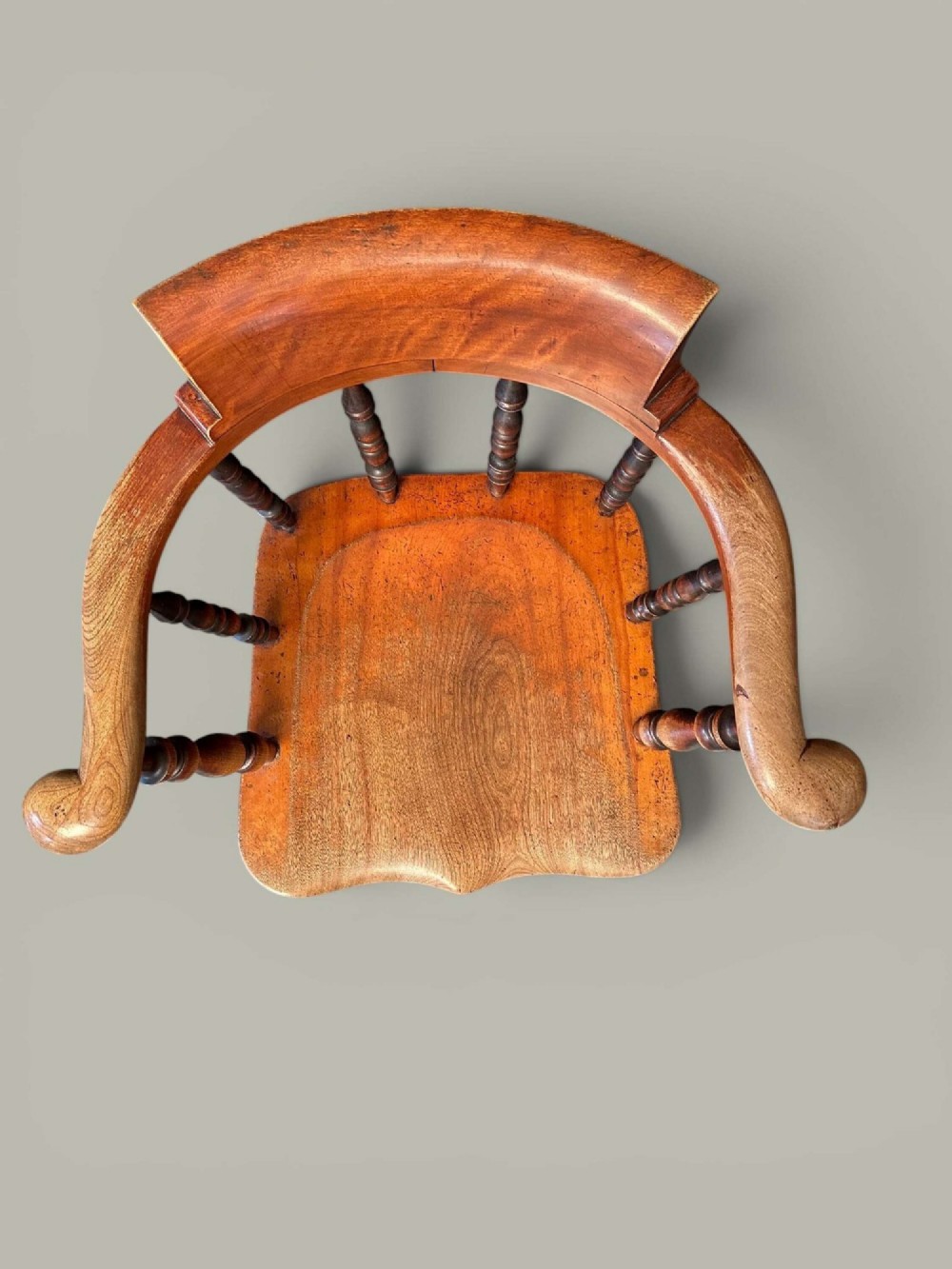 An antique alder wood Windsor captains chair featuring turned spindles, a contoured saddle seat, and high turned legs joined by stretchers. View VI