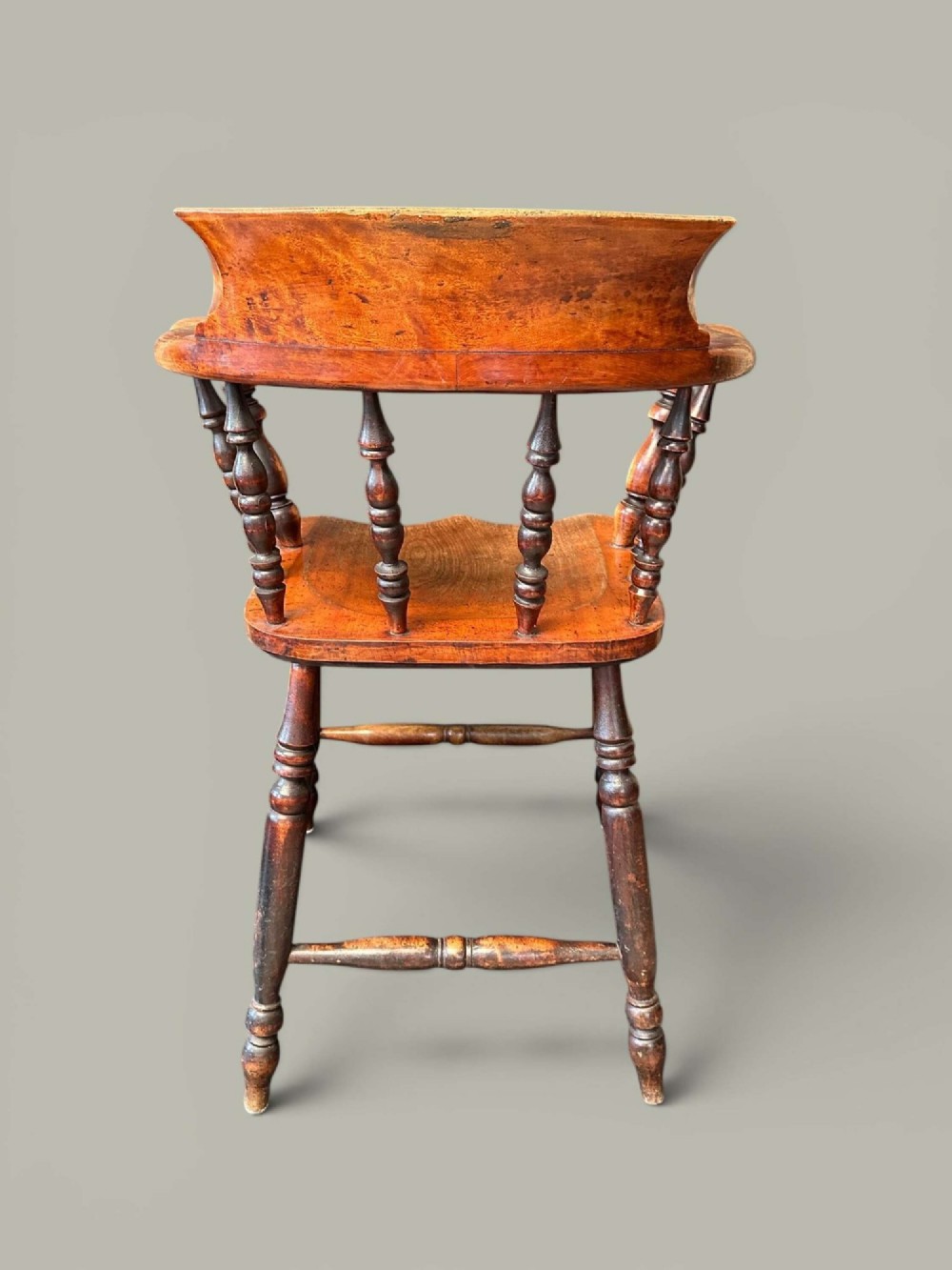 An antique alder wood Windsor captains chair featuring turned spindles, a contoured saddle seat, and high turned legs joined by stretchers. View IX