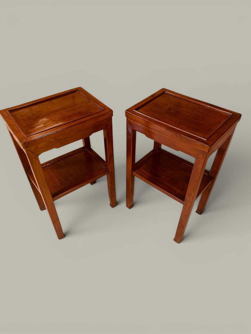 A pair of warm brown Chinese hardwood side tables featuring raised top borders, lower shelves, and straight square legs. View III