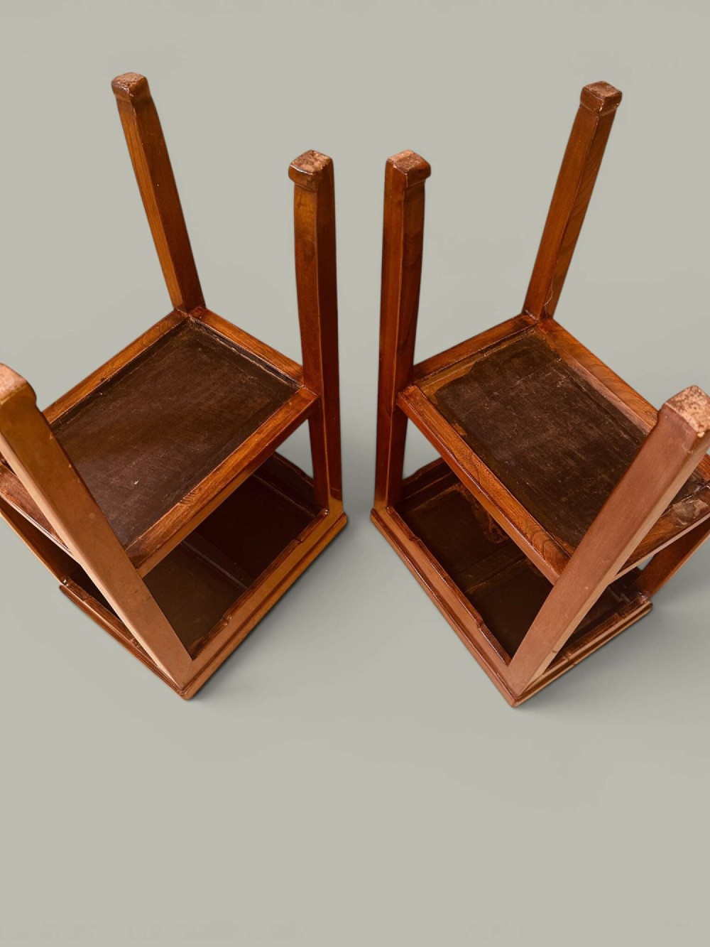 A pair of warm brown Chinese hardwood side tables featuring raised top borders, lower shelves, and straight square legs. View VII