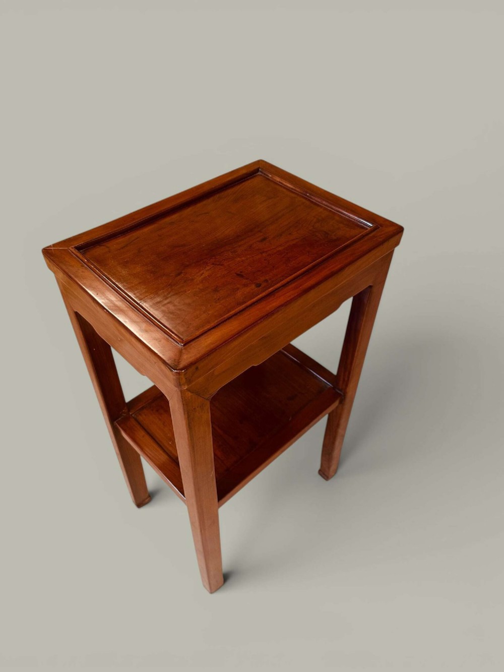 A pair of warm brown Chinese hardwood side tables featuring raised top borders, lower shelves, and straight square legs. View VIII