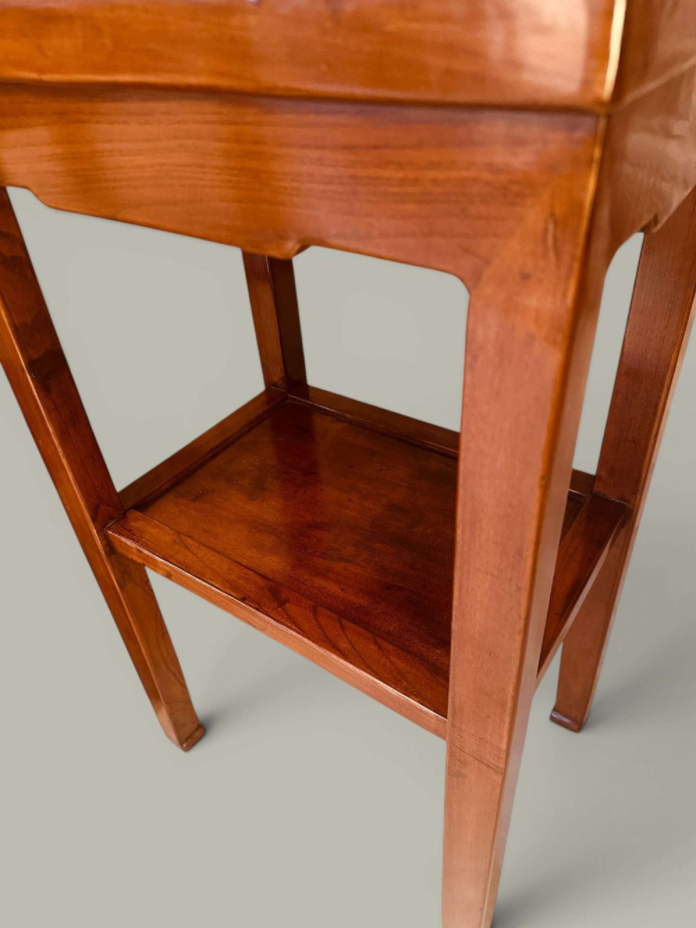 A pair of warm brown Chinese hardwood side tables featuring raised top borders, lower shelves, and straight square legs. View IX