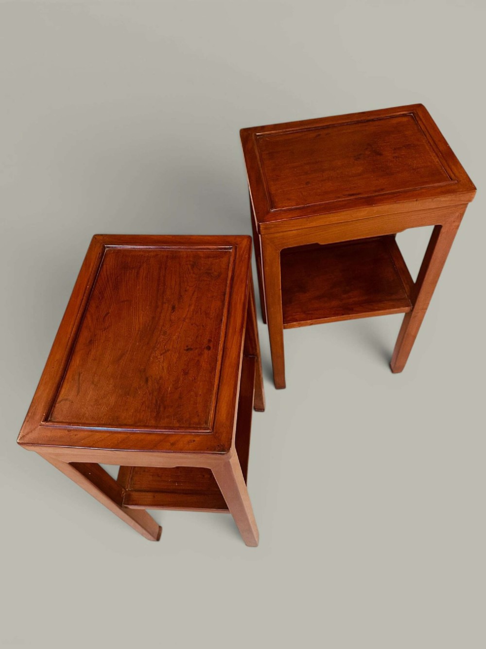 A pair of warm brown Chinese hardwood side tables featuring raised top borders, lower shelves, and straight square legs. View XI