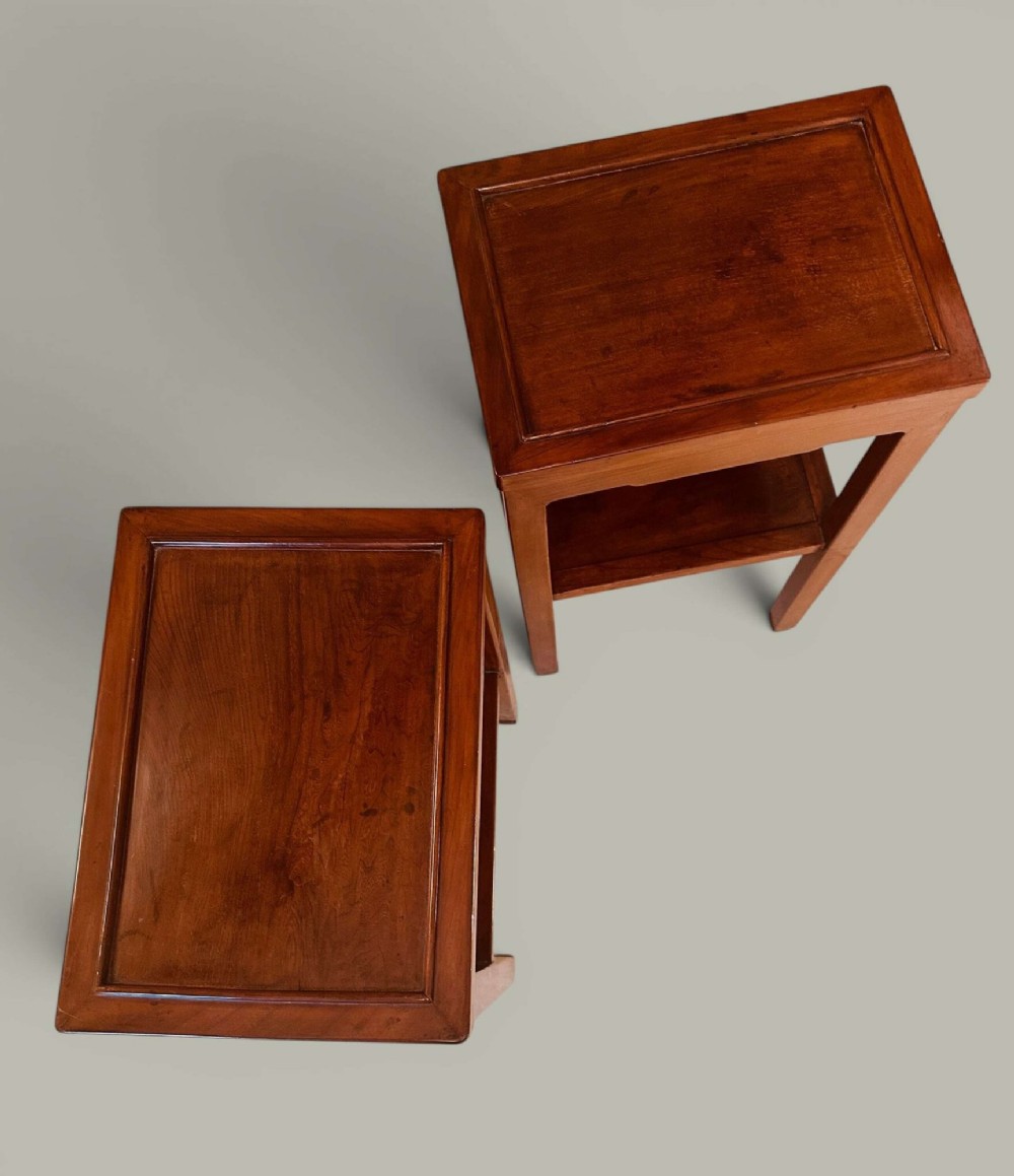 A pair of warm brown Chinese hardwood side tables featuring raised top borders, lower shelves, and straight square legs. View XII