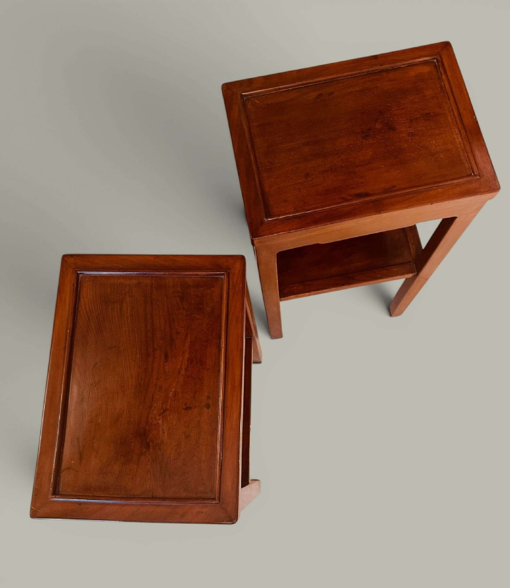 A pair of warm brown Chinese hardwood side tables featuring raised top borders, lower shelves, and straight square legs. View XIII