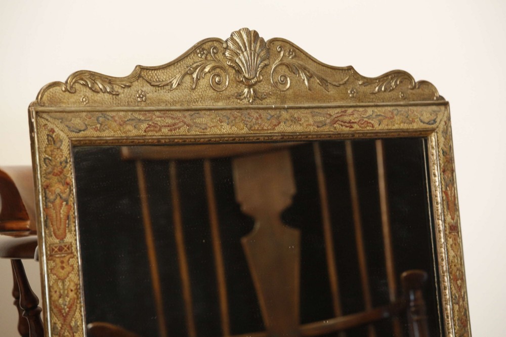 A 19th-century rectangular cushion wall mirror featuring an embroidered tapestry border, an ornamental gilt crest with a shell motif, and a glass plate. View IV