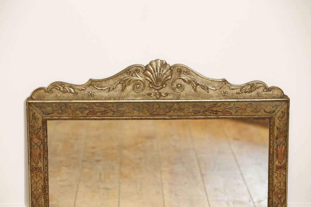 A 19th-century rectangular cushion wall mirror featuring an embroidered tapestry border, an ornamental gilt crest with a shell motif, and a glass plate. View X