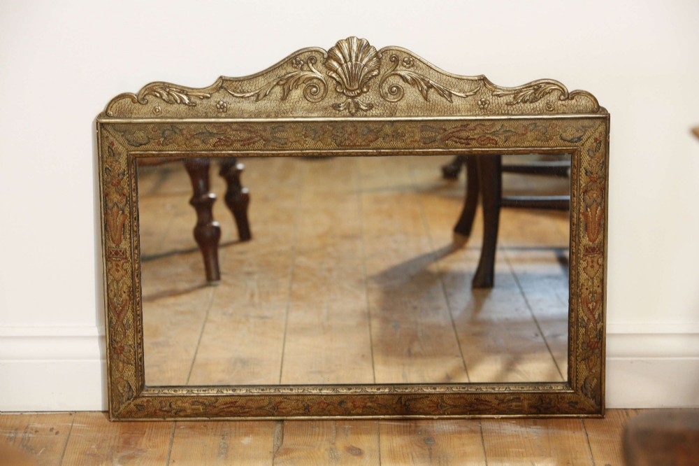A 19th-century rectangular cushion wall mirror featuring an embroidered tapestry border, an ornamental gilt crest with a shell motif, and a glass plate. View XII