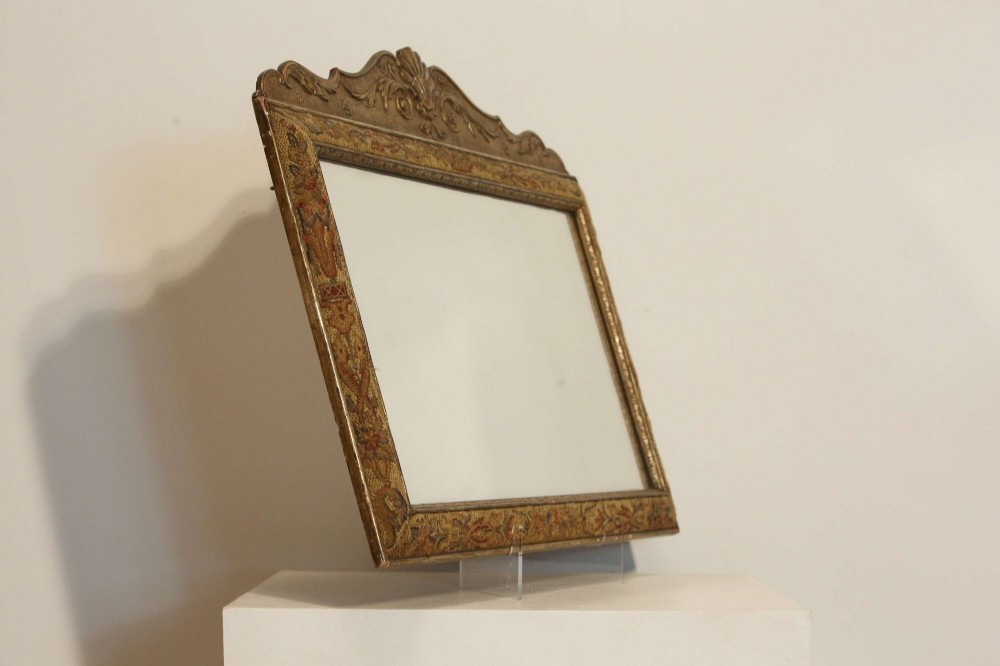 A 19th-century rectangular cushion wall mirror featuring an embroidered tapestry border, an ornamental gilt crest with a shell motif, and a glass plate. View XIV