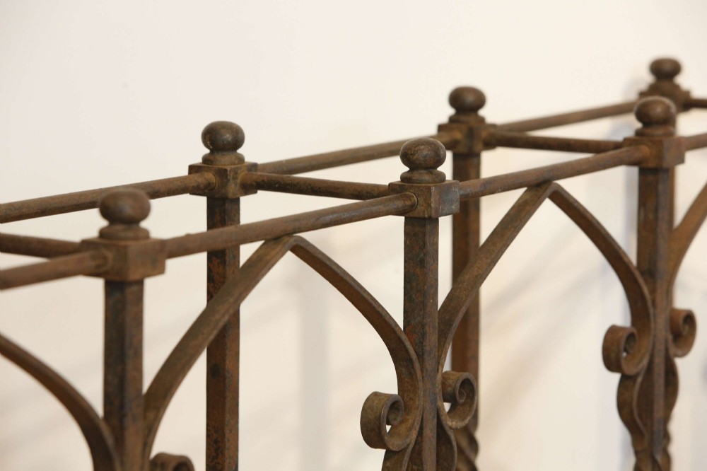 A rectangular Victorian Gothic Revival wrought iron umbrella stand featuring pointed tracery arches, twisted corner posts with ball finials, and a removable green metal drip tray. View III