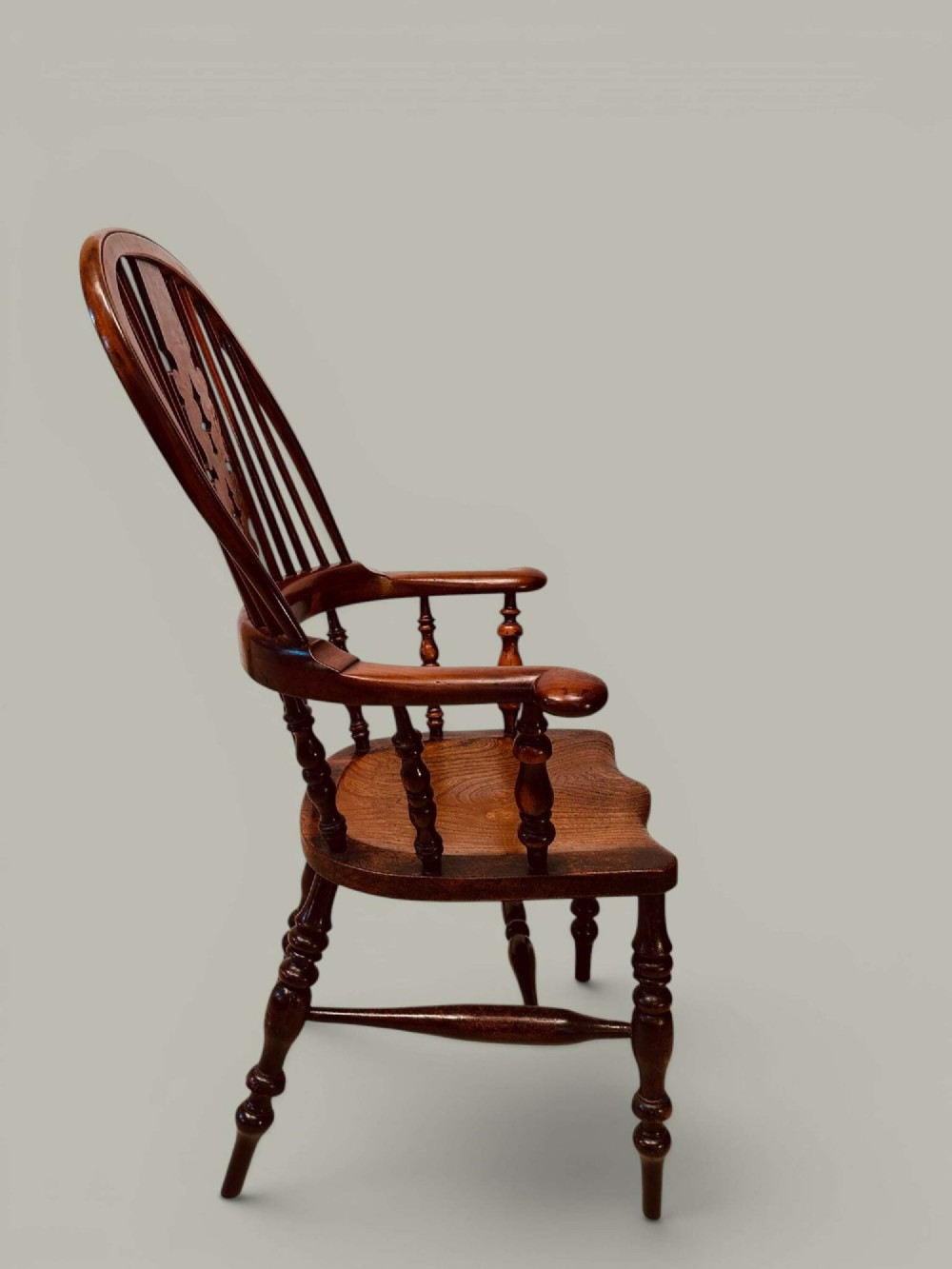 A pair of 19th-century yew and elm Windsor armchairs featuring curved hoop backs, pierced central splats, broad armrests, and turned legs. View III