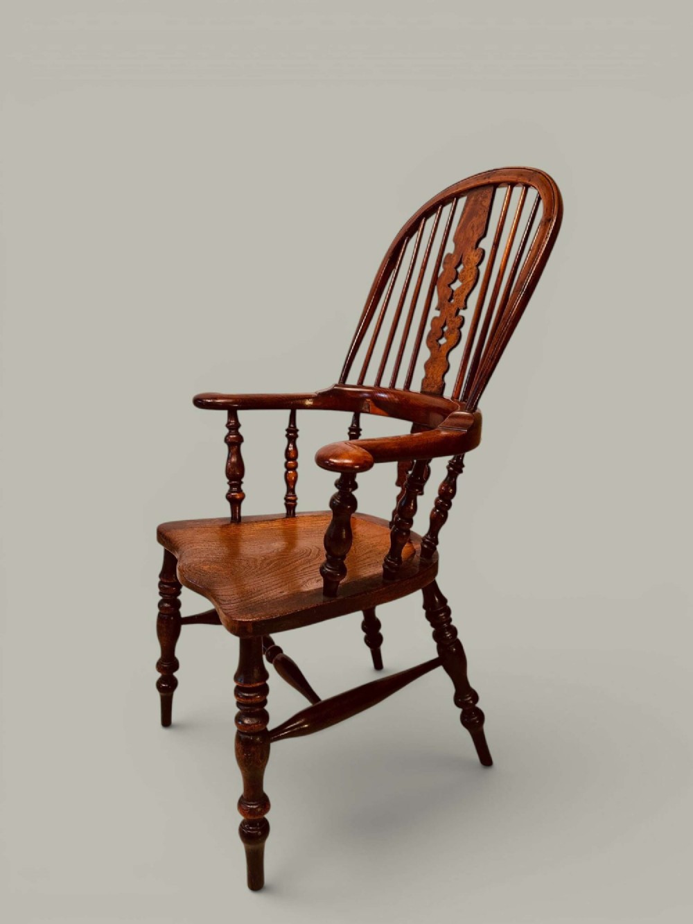 A pair of 19th-century yew and elm Windsor armchairs featuring curved hoop backs, pierced central splats, broad armrests, and turned legs. View IV