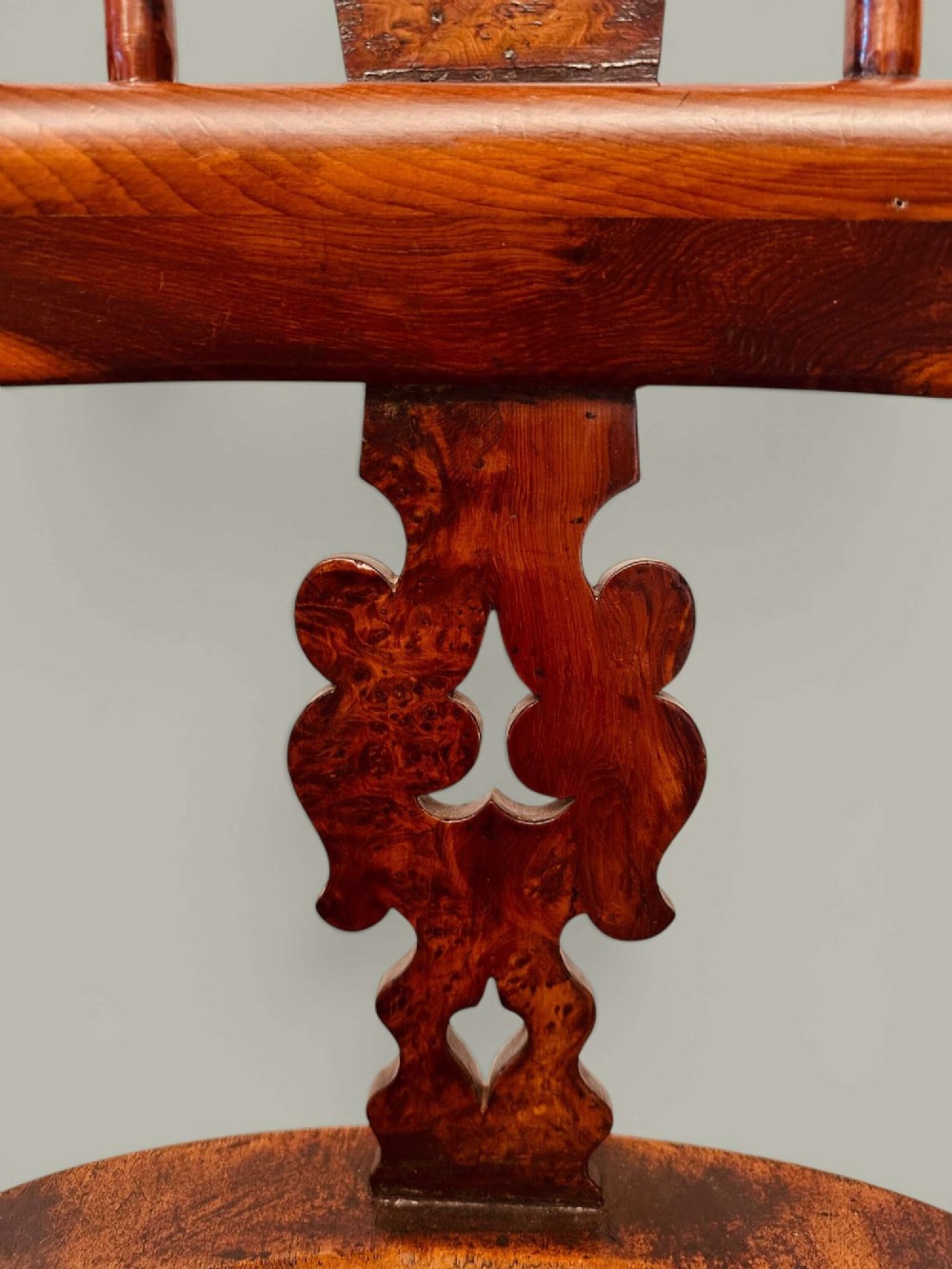A pair of 19th-century yew and elm Windsor armchairs featuring curved hoop backs, pierced central splats, broad armrests, and turned legs. View VII