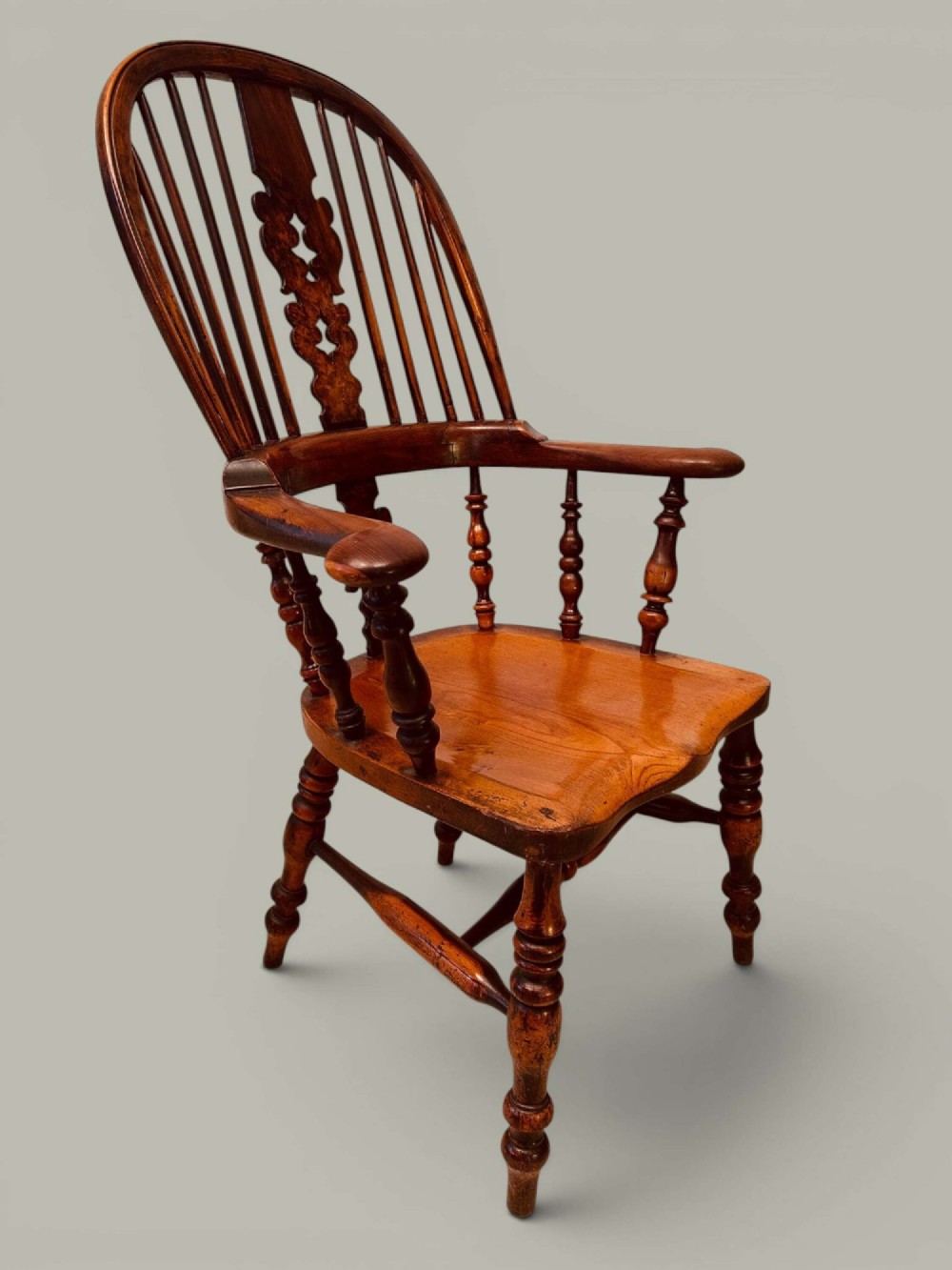 A pair of 19th-century yew and elm Windsor armchairs featuring curved hoop backs, pierced central splats, broad armrests, and turned legs. View XII