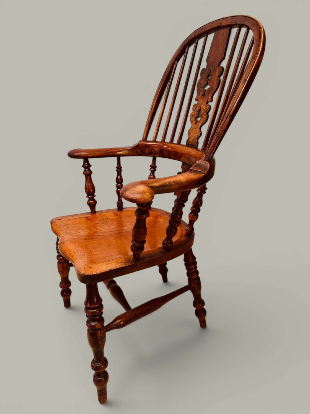 A pair of 19th-century yew and elm Windsor armchairs featuring curved hoop backs, pierced central splats, broad armrests, and turned legs. View XIII