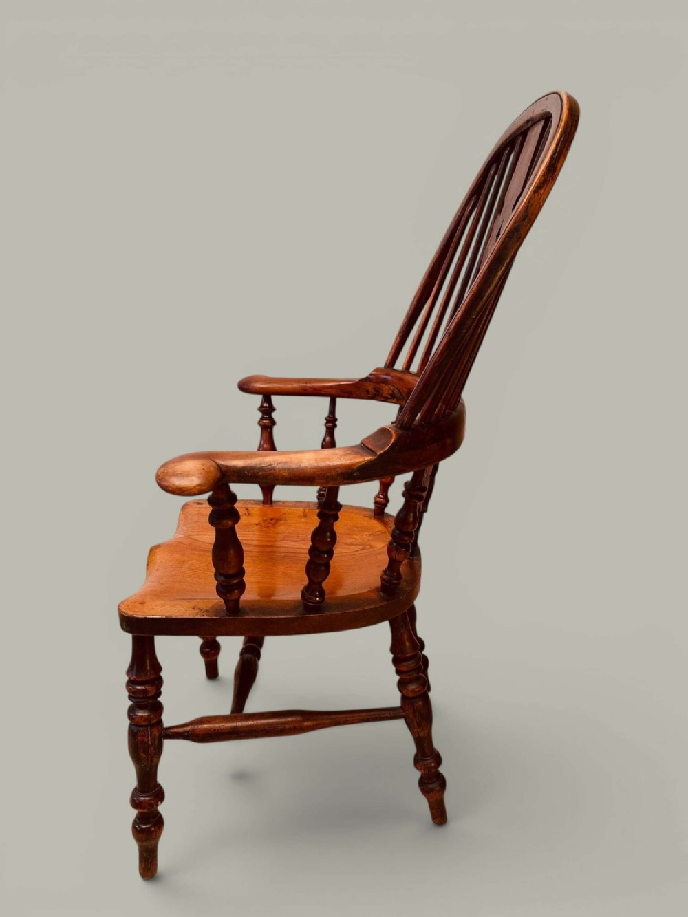 A pair of 19th-century yew and elm Windsor armchairs featuring curved hoop backs, pierced central splats, broad armrests, and turned legs. View XIV