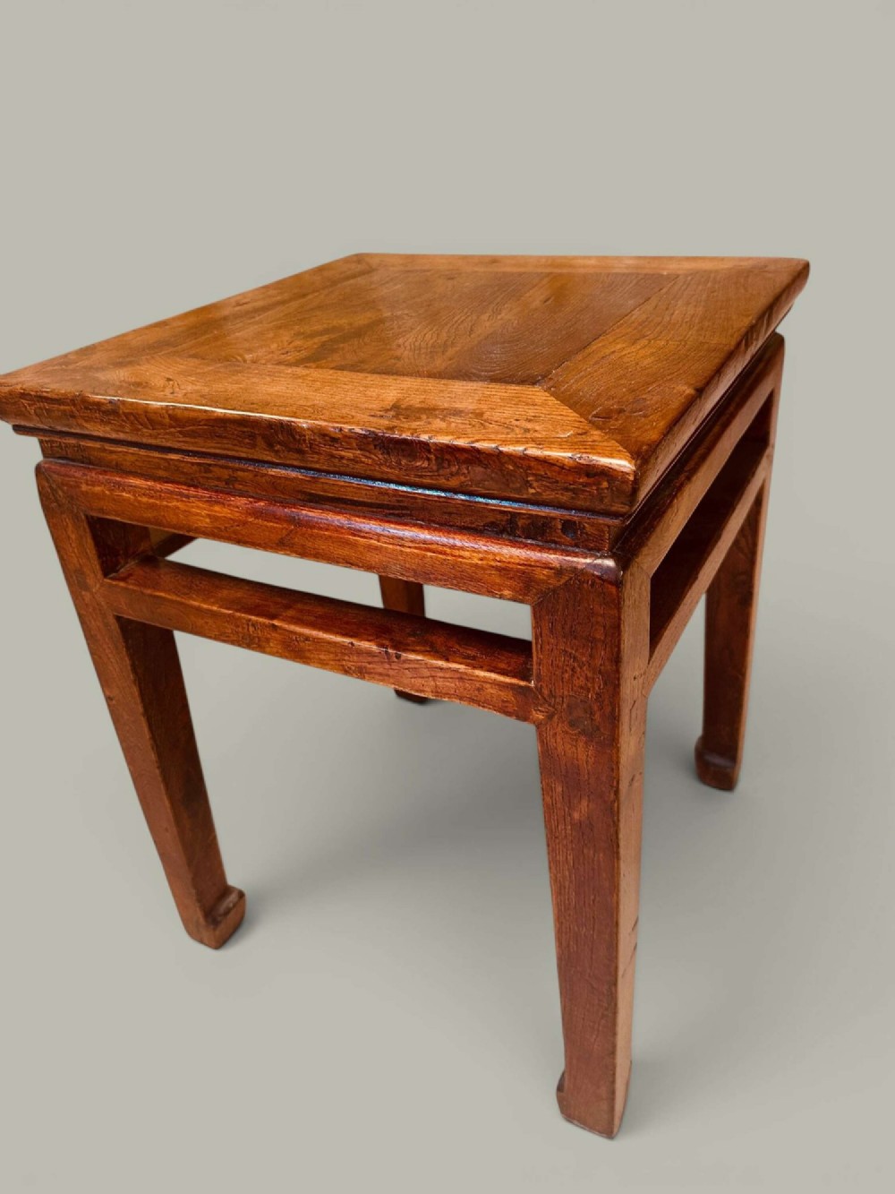 A near pair of square late 19th-century Chinese elm side tables with panelled tops, straight legs, and stretchers in a warm brown timber finish. View V