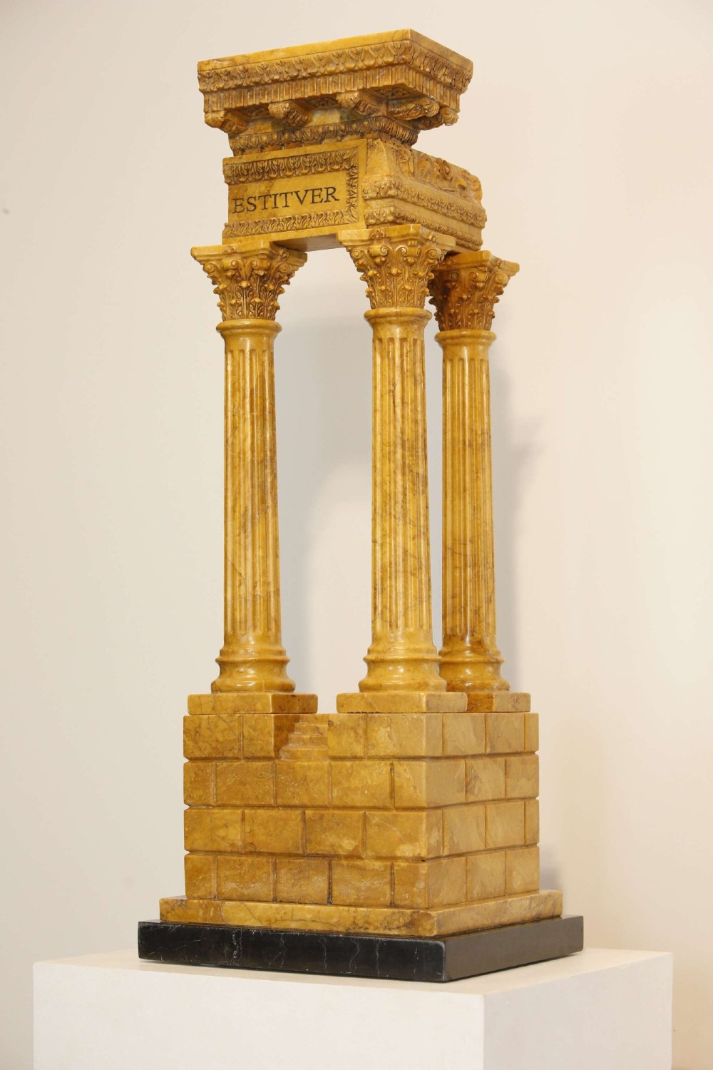 A 19th-century Grand Tour sienna marble architectural model depicting three fluted Corinthian columns of the Temple of Vespasian mounted on a black marble base. View II