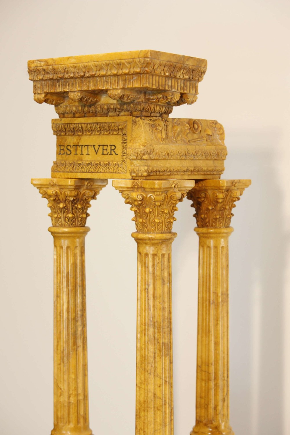 A 19th-century Grand Tour sienna marble architectural model depicting three fluted Corinthian columns of the Temple of Vespasian mounted on a black marble base. View IV