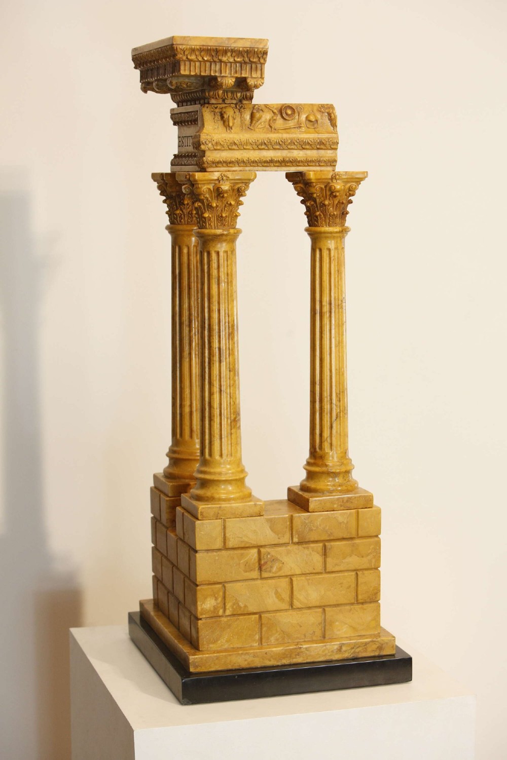 A 19th-century Grand Tour sienna marble architectural model depicting three fluted Corinthian columns of the Temple of Vespasian mounted on a black marble base. View VII