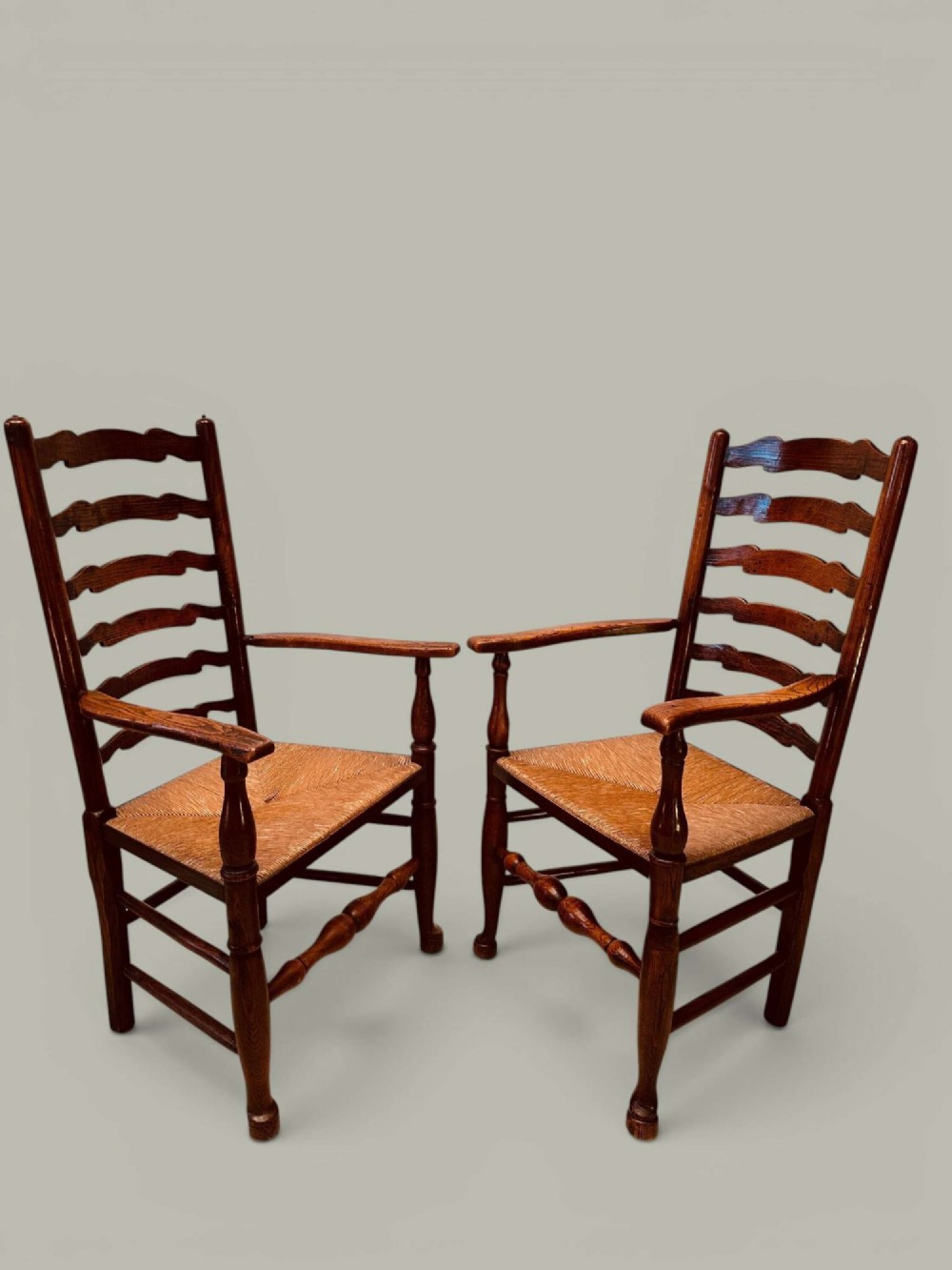 A set of eight antique ash dining chairs featuring wavy ladder backs, turned stretchers, and woven rush seats, comprising six side chairs and two carver armchairs. View VI