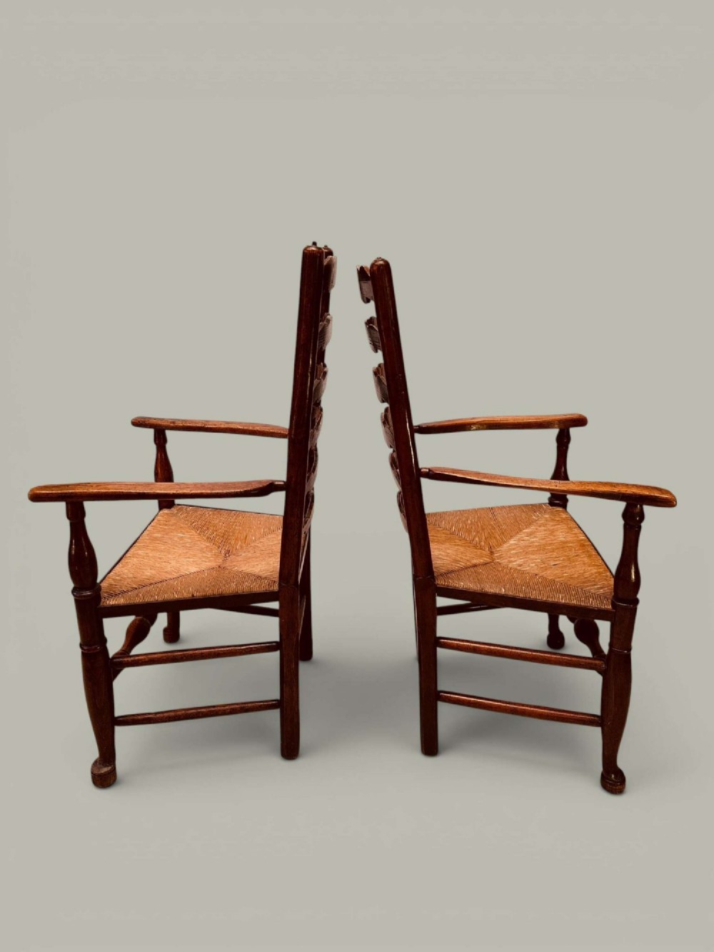 A set of eight antique ash dining chairs featuring wavy ladder backs, turned stretchers, and woven rush seats, comprising six side chairs and two carver armchairs. View VII